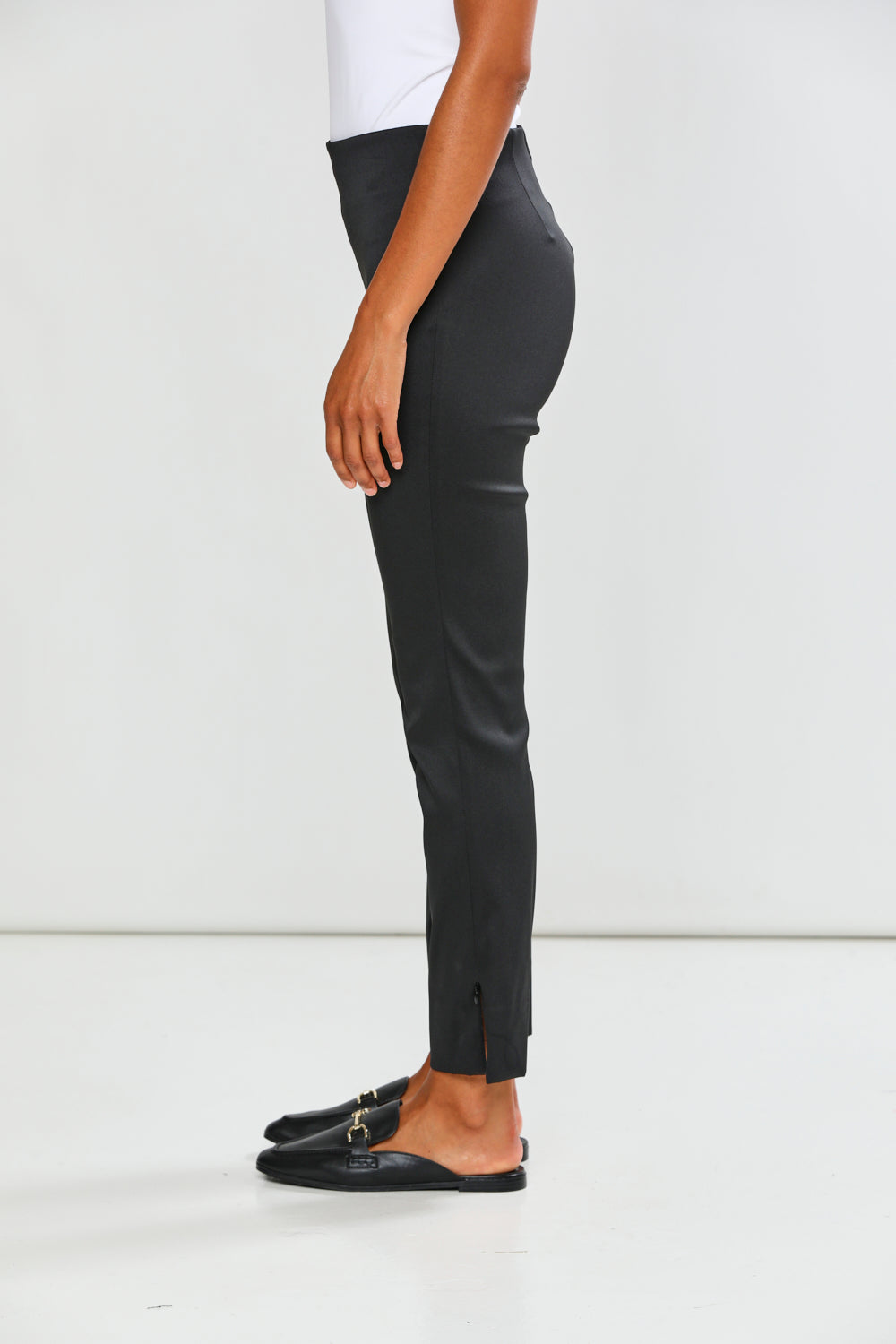 Person wearing black pants on a white background