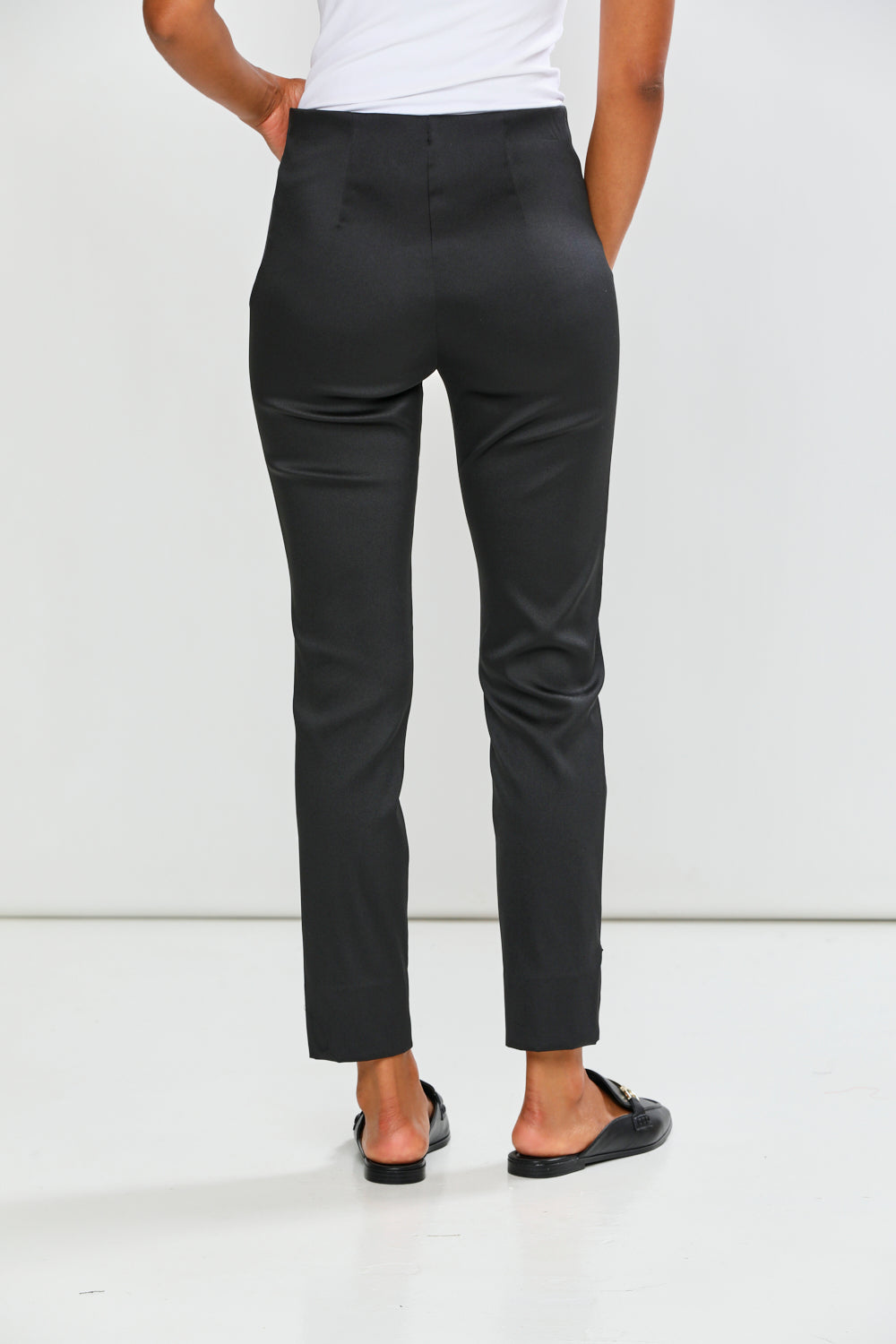 Person wearing black pants on a white background