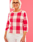 Woman in pink gingham sweater