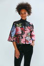 Woman wearing a floral blouse with black pants on a white background