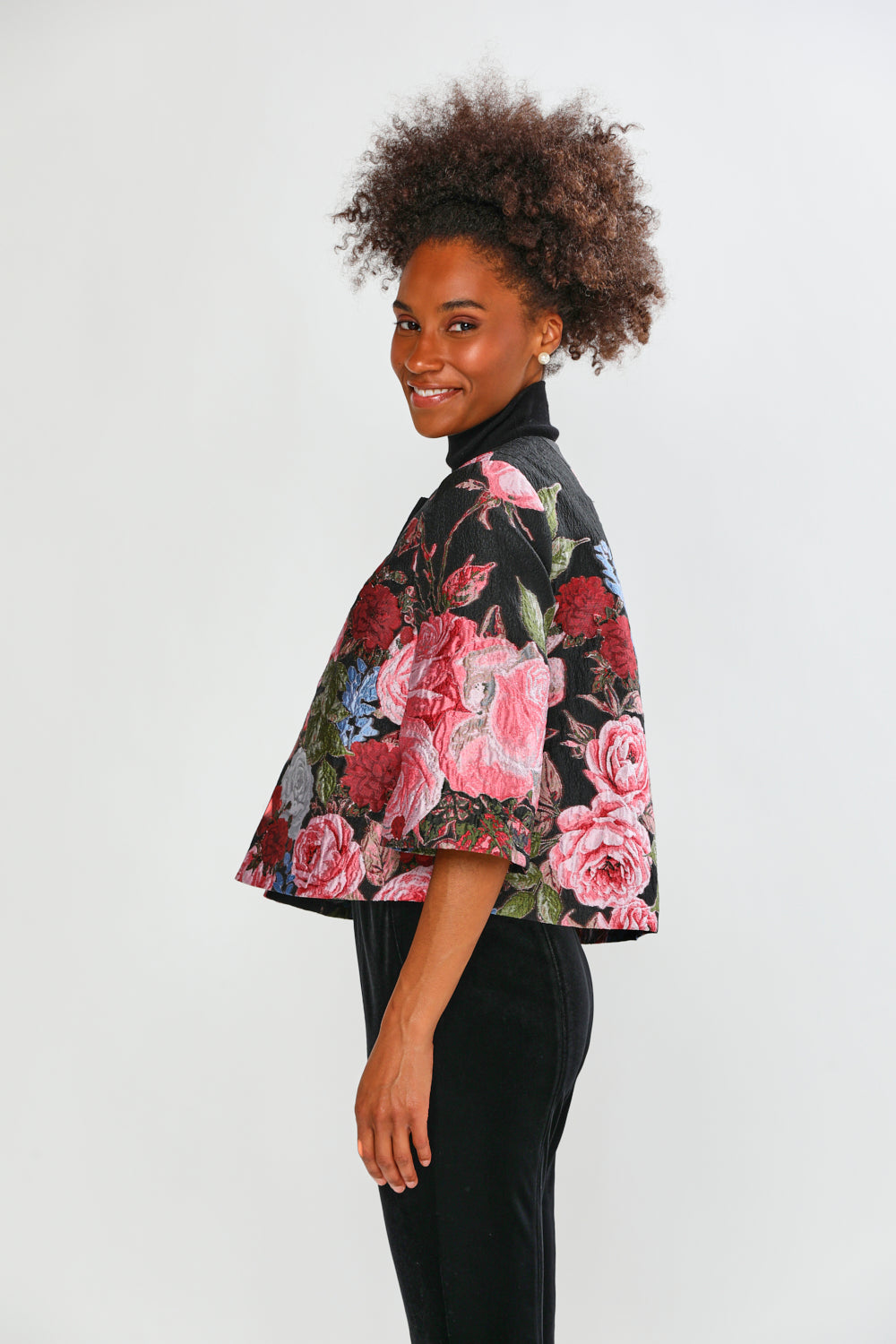 Woman wearing a floral jacket on a white background