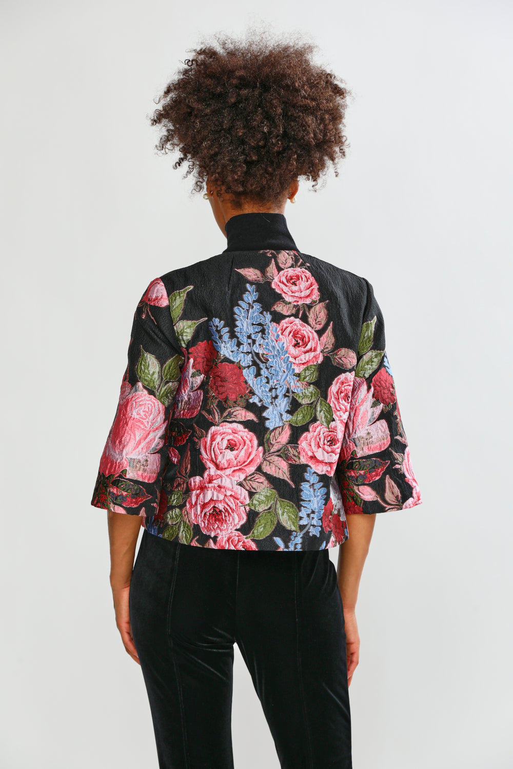 Person wearing a floral-patterned jacket on a white background
