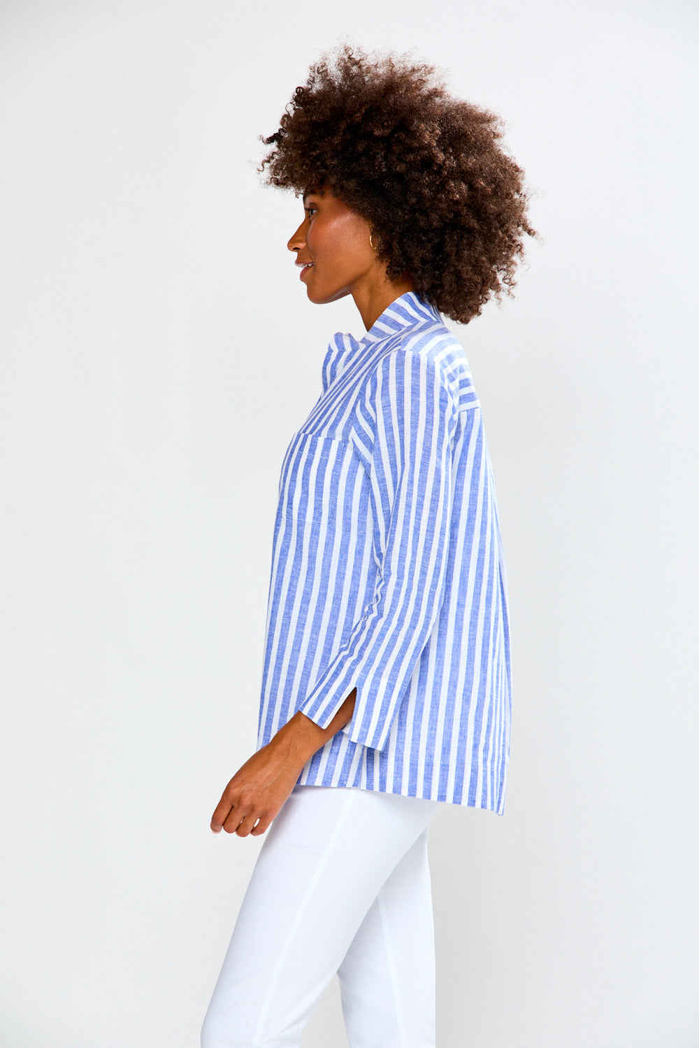 Woman wearing a blue and white striped shirt against a white background