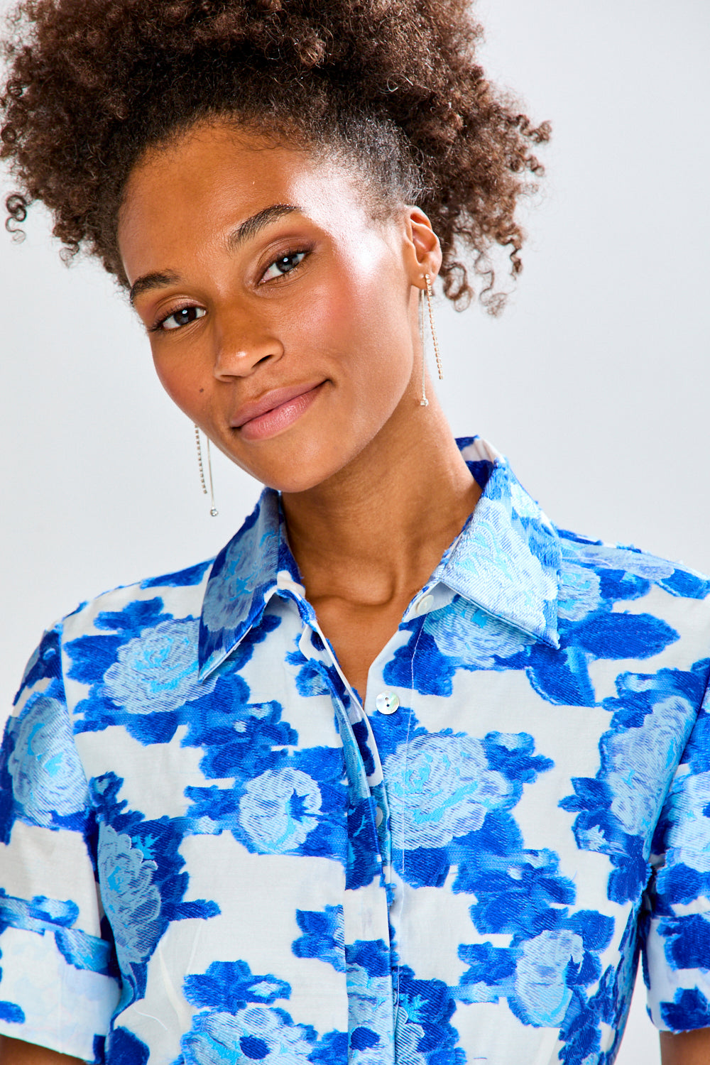 Woman wearing a blue floral dress against a white background