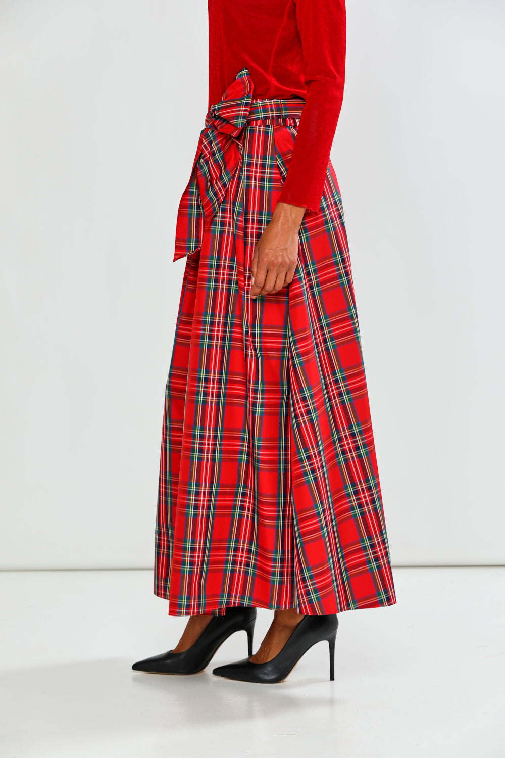Person wearing a red plaid skirt with a white background