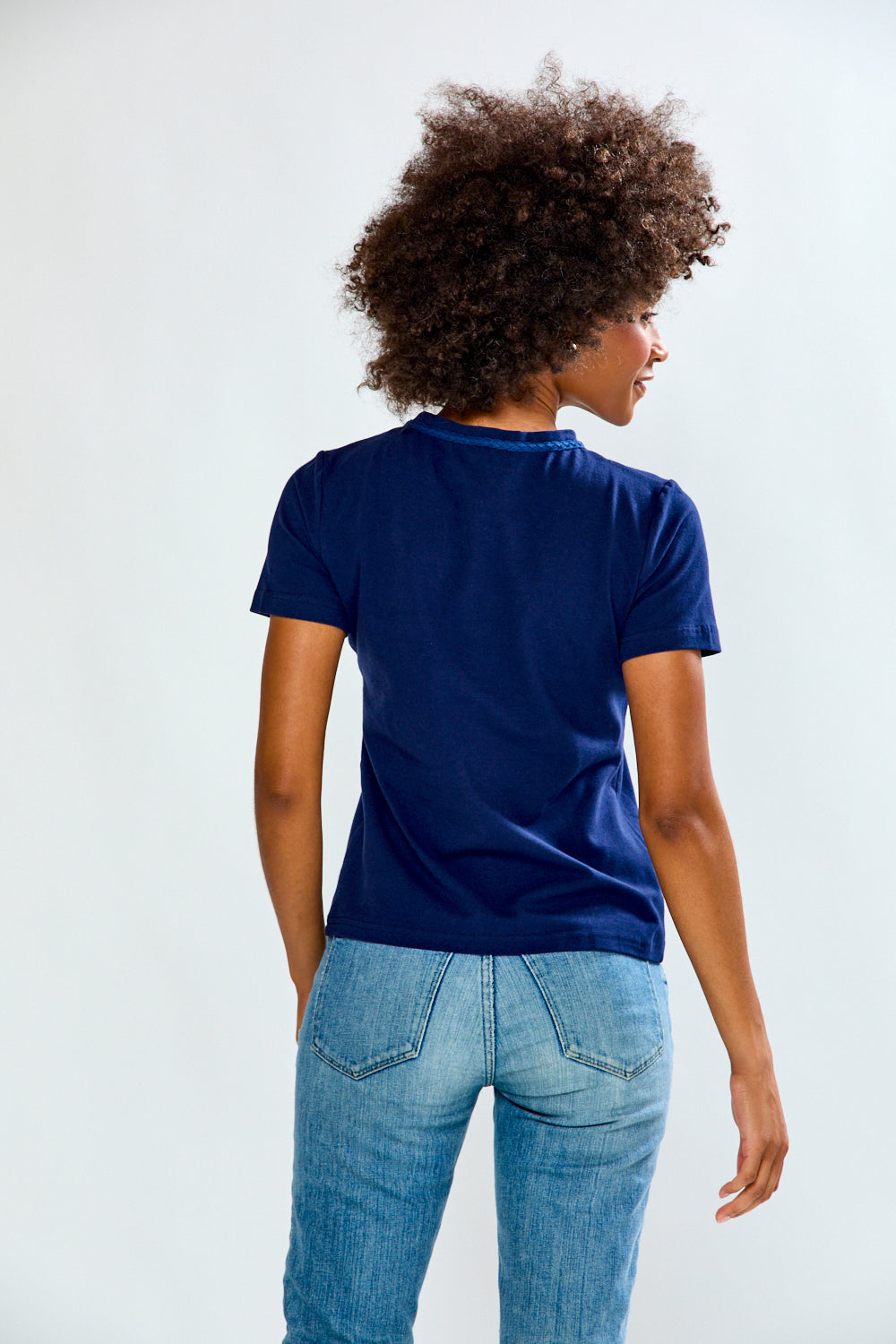 Person wearing a blue t-shirt and jeans on a white background