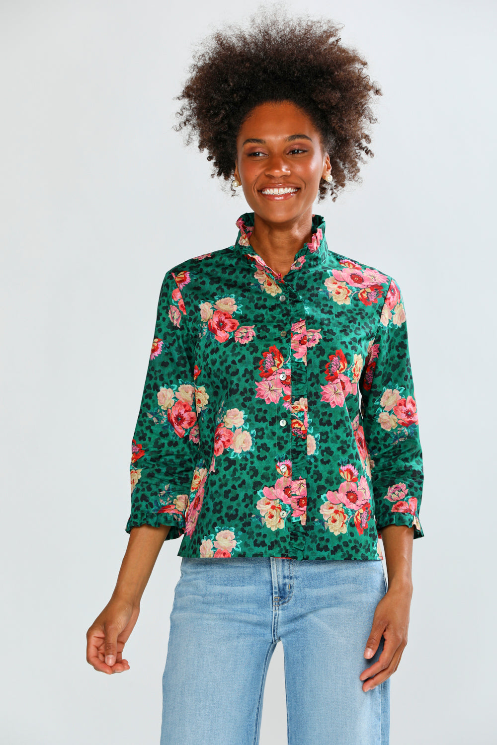 Woman wearing a floral patterned shirt with a green background