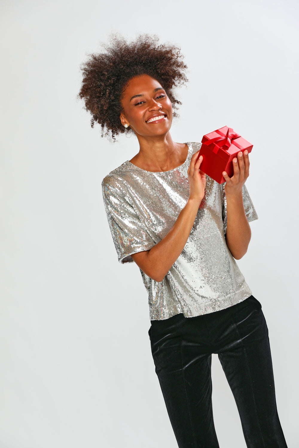 Woman holding a red gift box against a white background