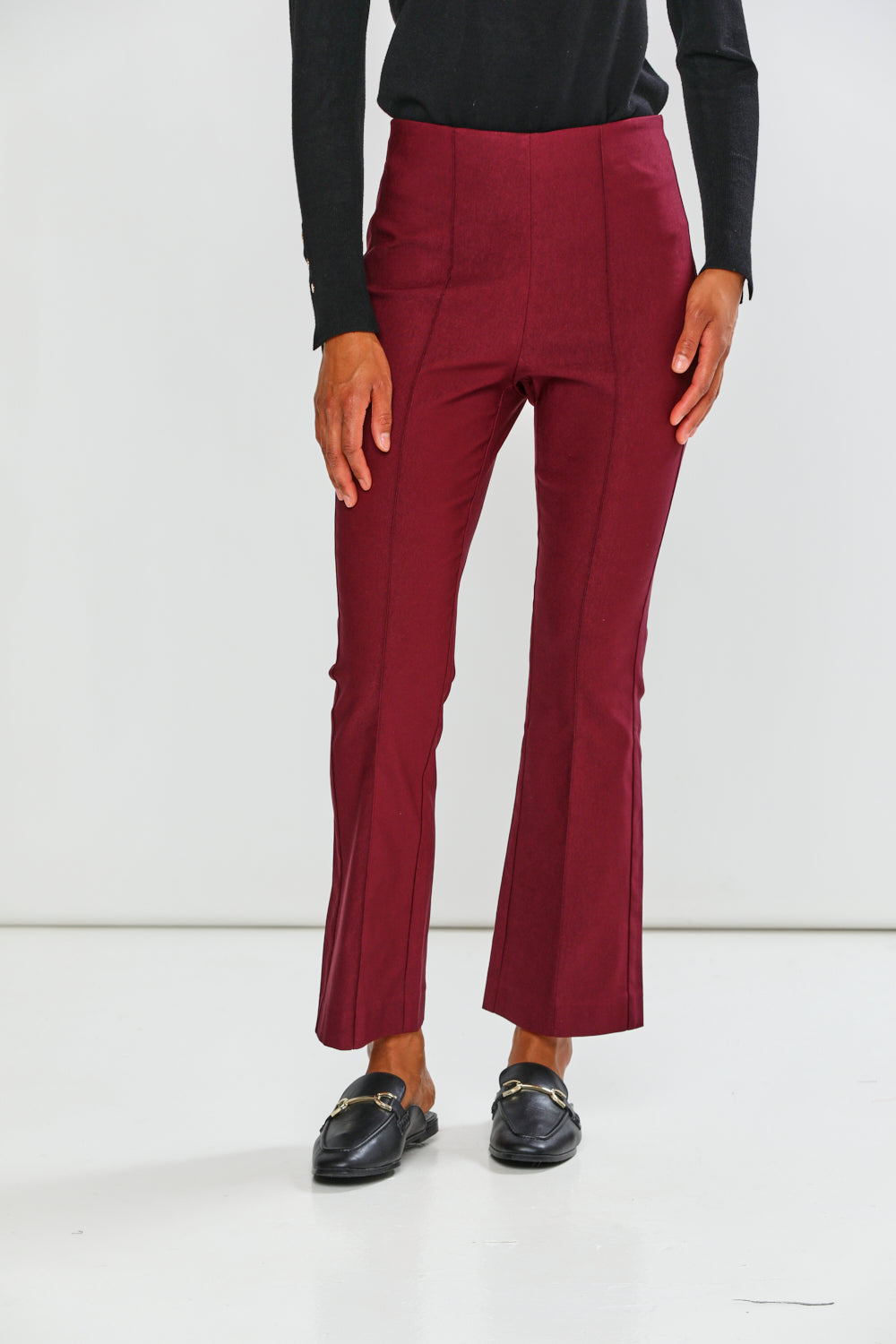 Maroon pants worn by a person on a white background