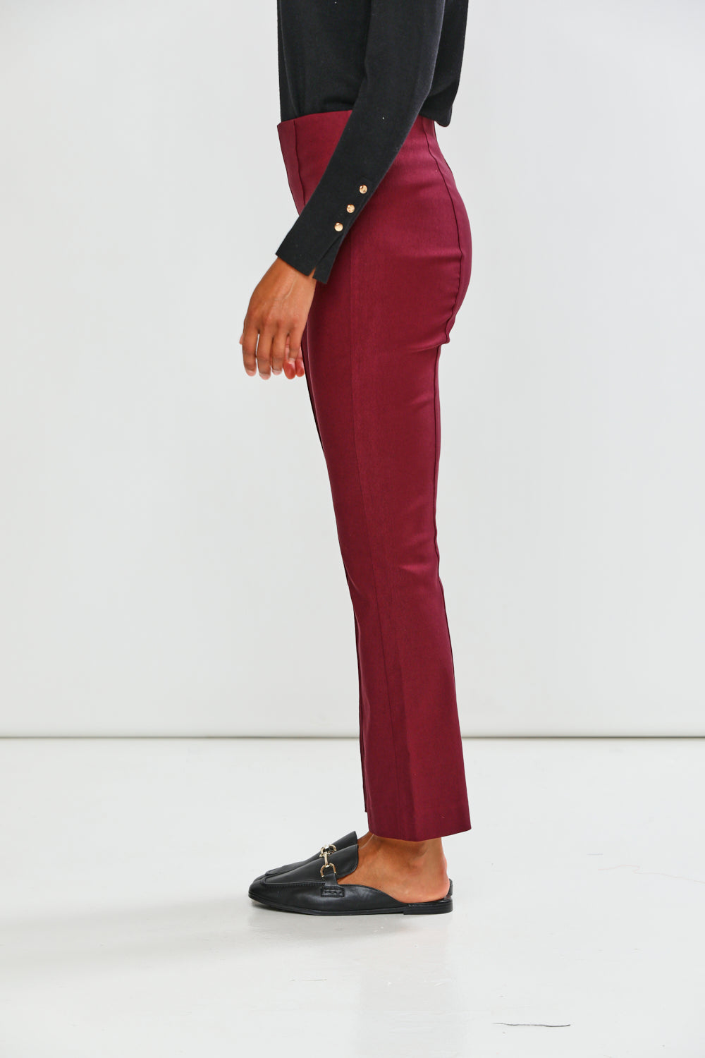 Maroon pants worn by a person on a white background