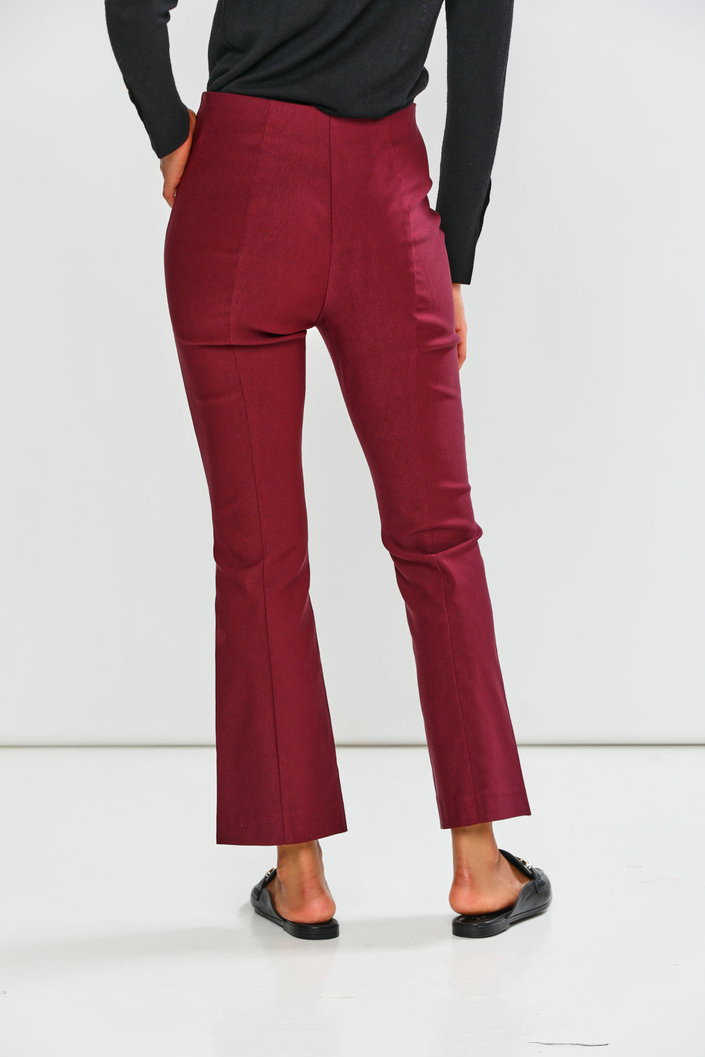 Maroon pants worn by a person on a white background