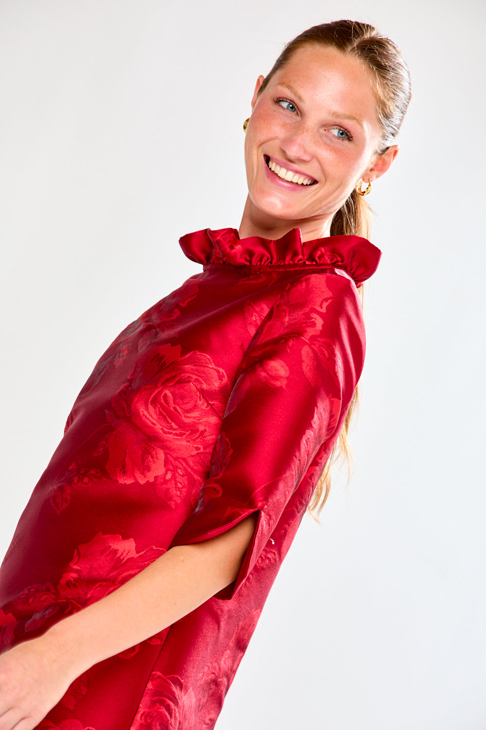Woman wearing a red dress with floral pattern on a white background
