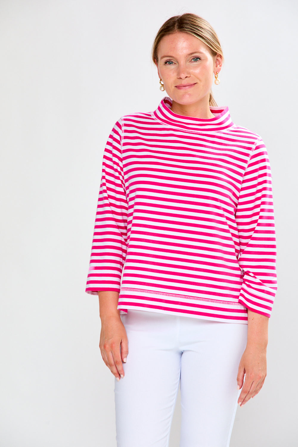 Woman wearing a pink and white striped sweater against a white background