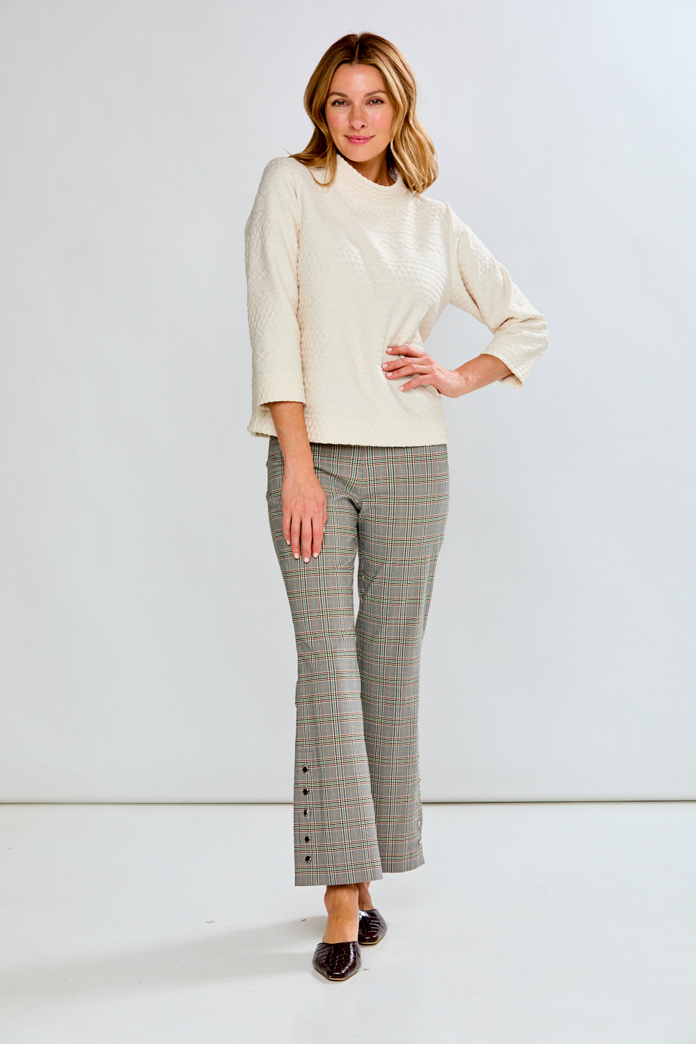 Person wearing plaid pants on a white background