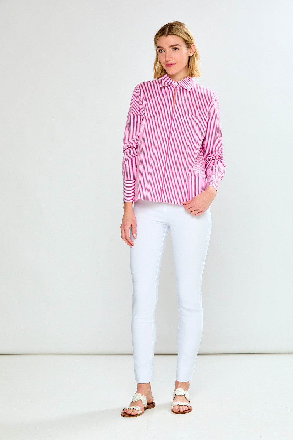 Woman wearing a pink and white striped shirt against a plain background