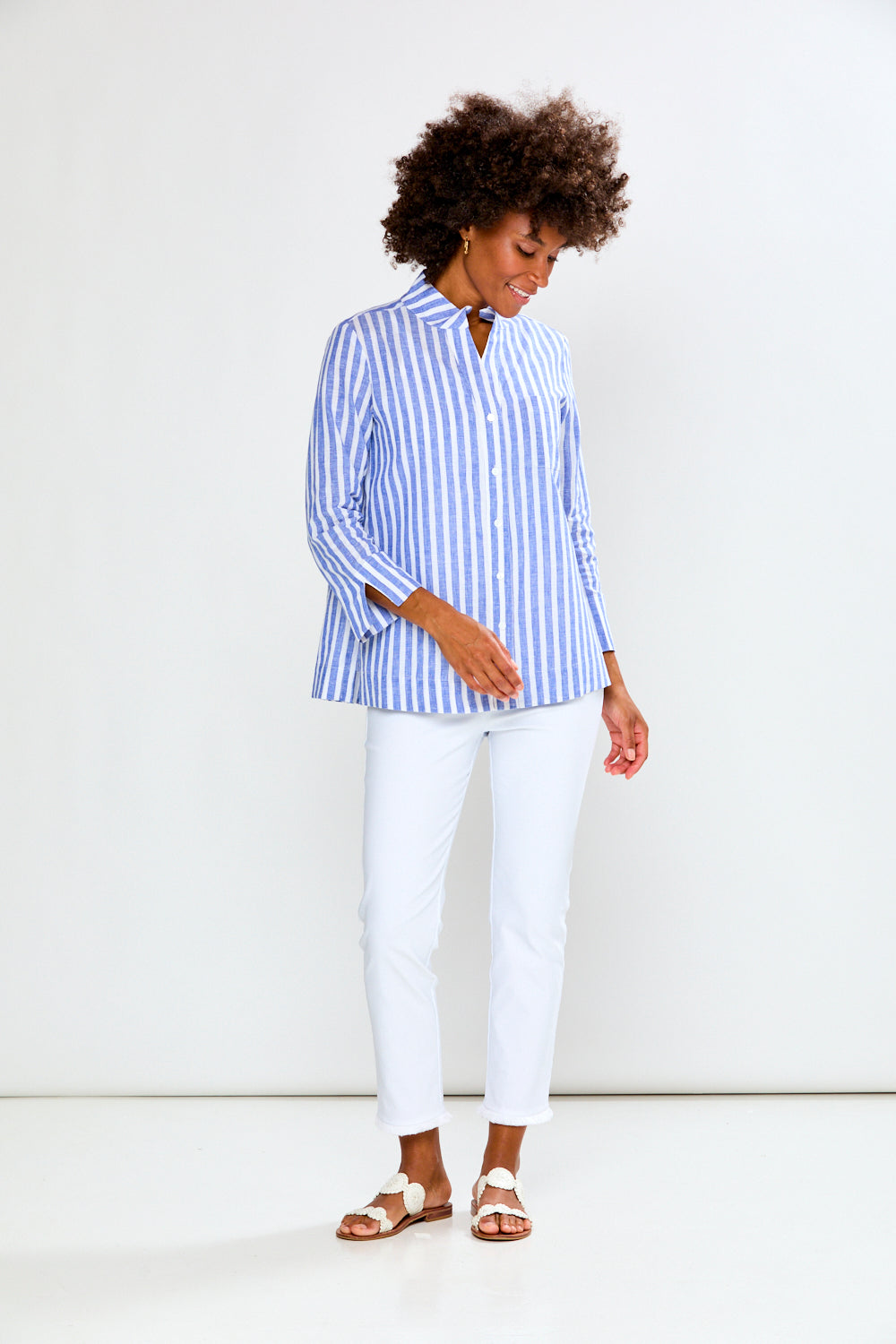 Woman wearing a blue and white striped shirt against a white background