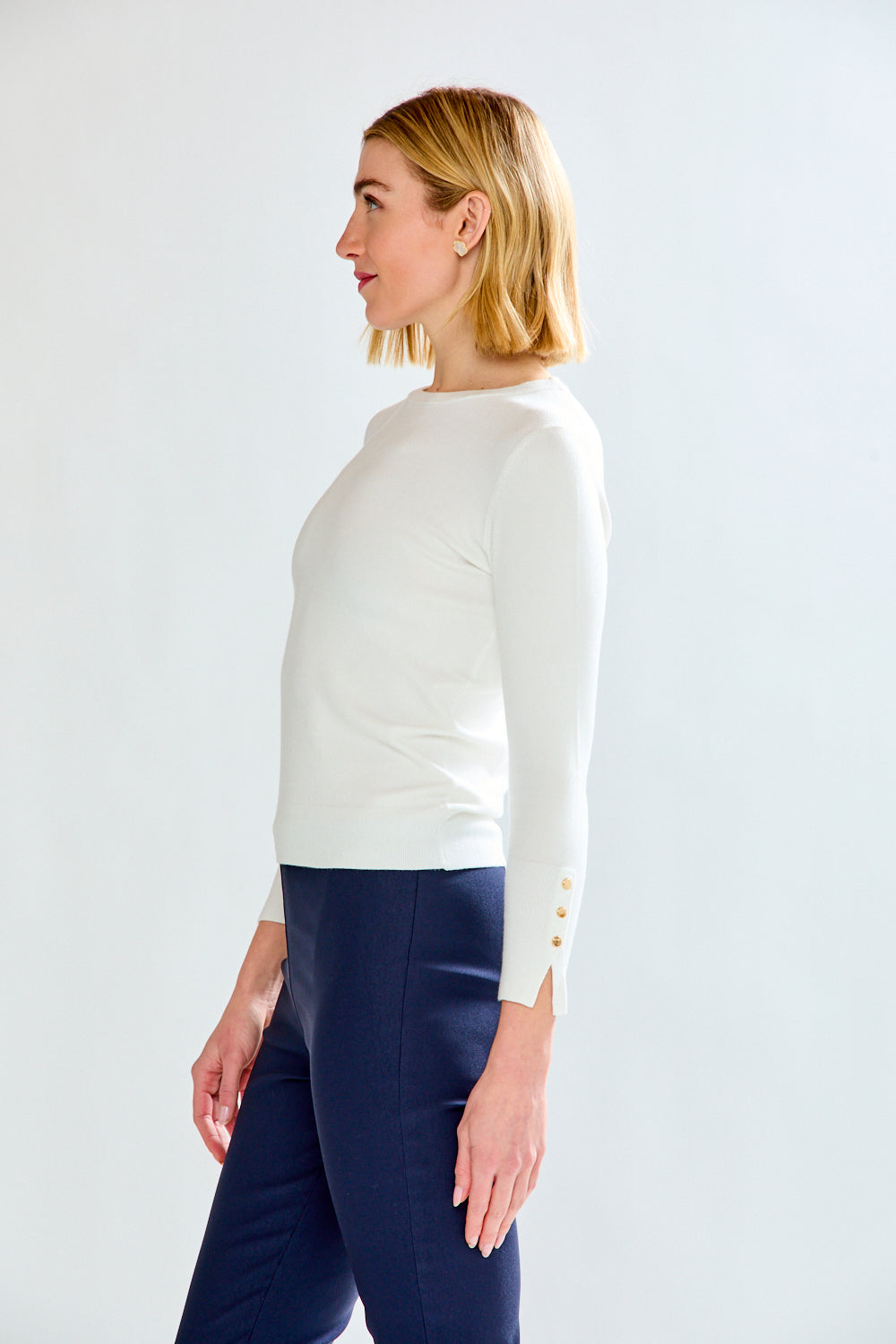 woman in white sweater and navy pants