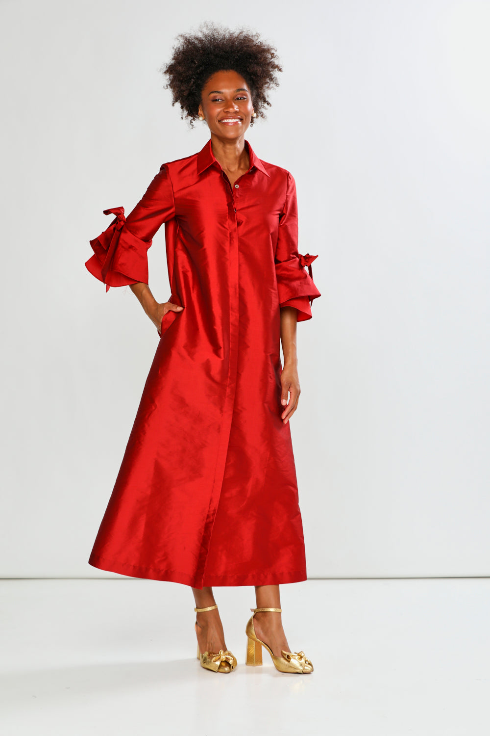 Woman wearing a red dress with ruffled sleeves on a white background