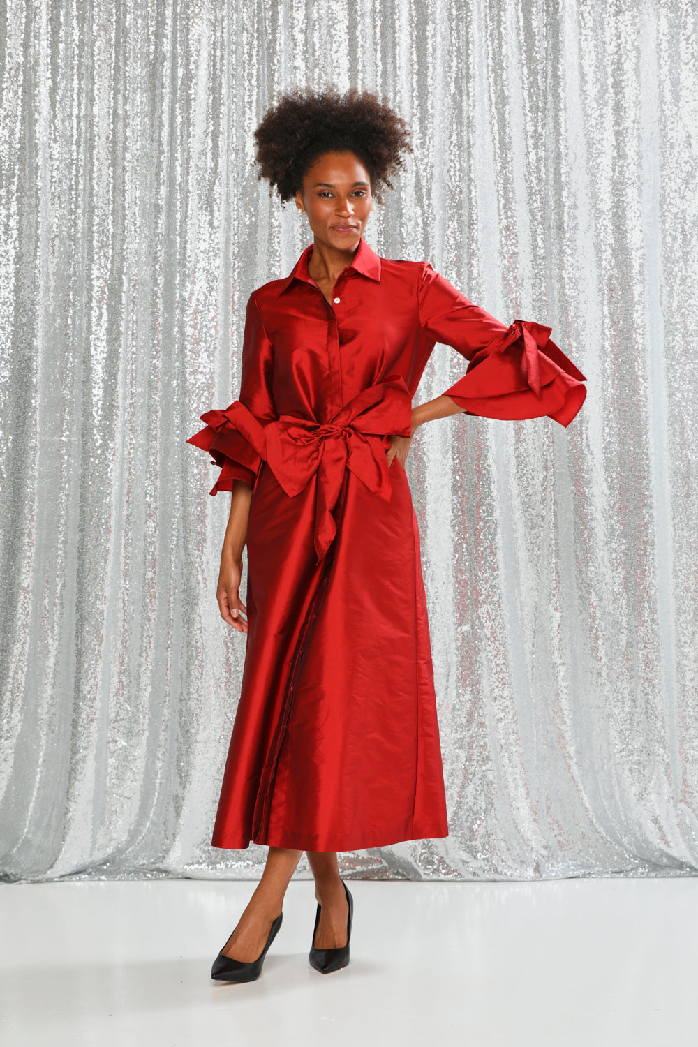 Woman wearing a red dress with a silver textured backdrop