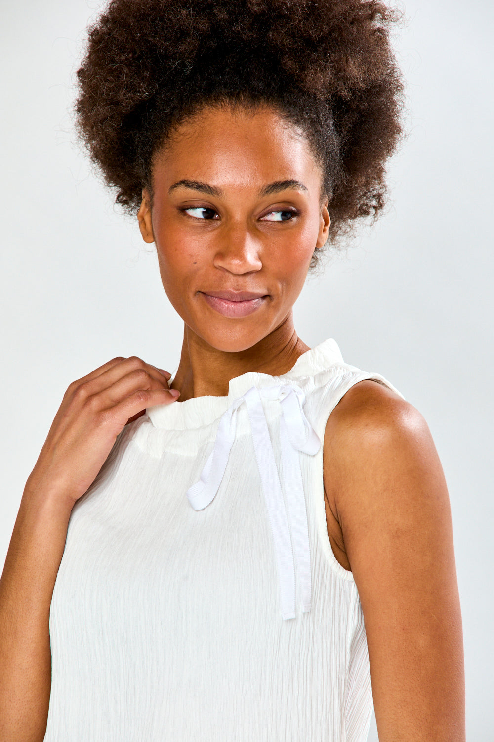 Woman in ivory sleeveless blouse