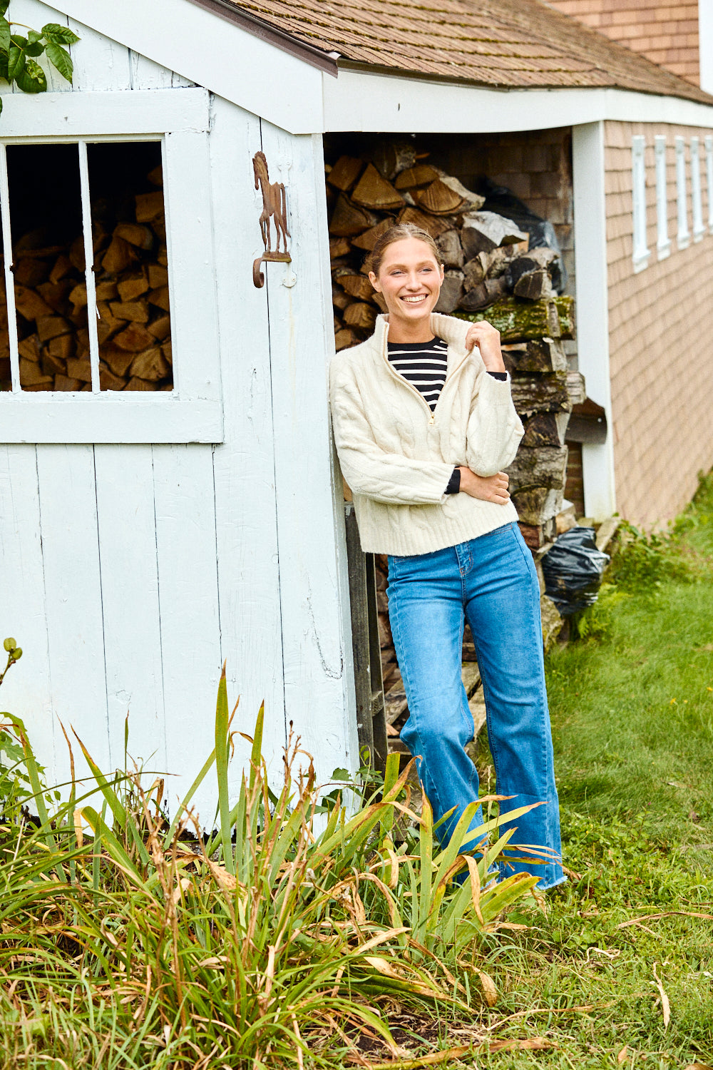 Woman wearing a black and white striped sweater and blue jeans