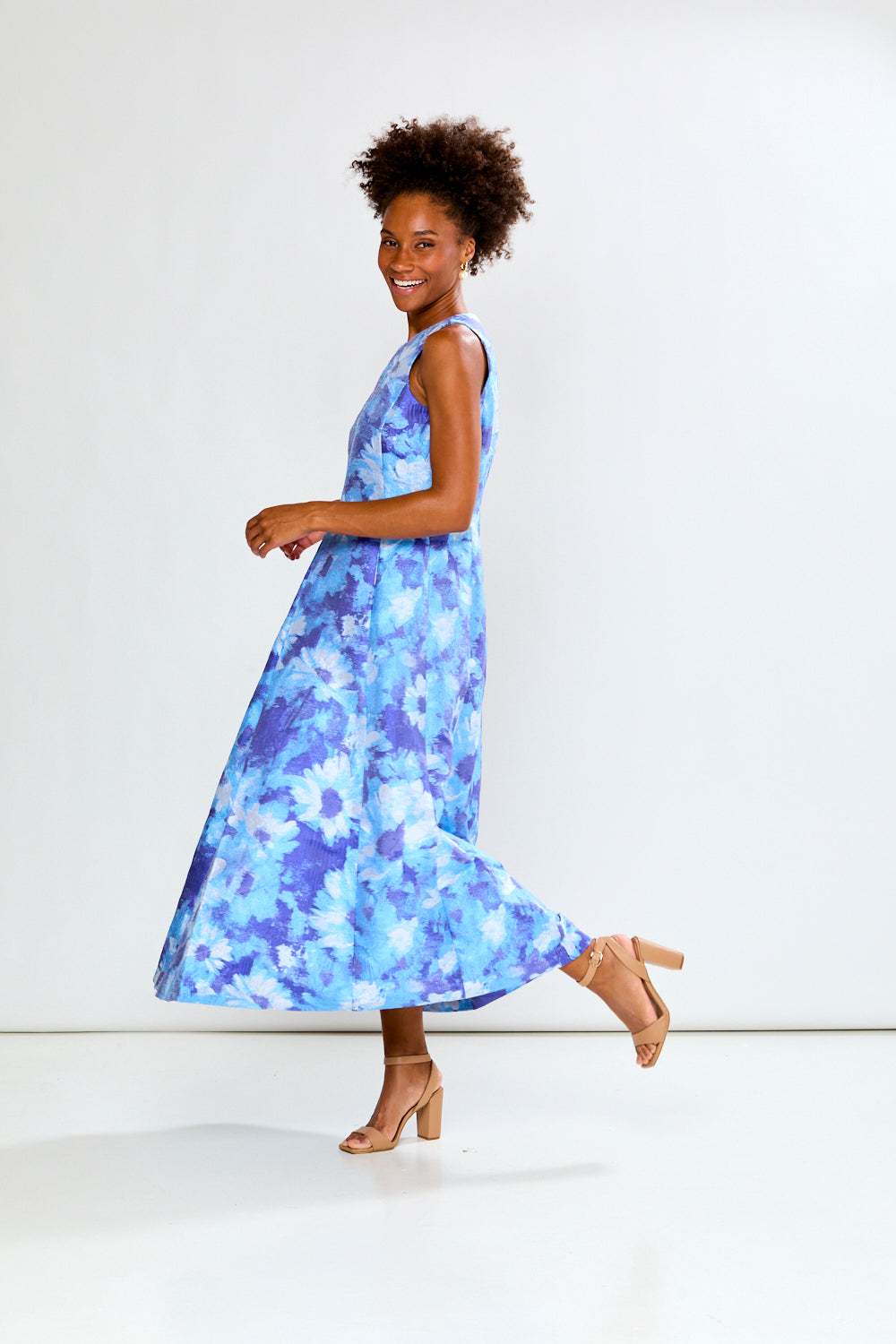 Woman wearing a blue floral dress against a white background