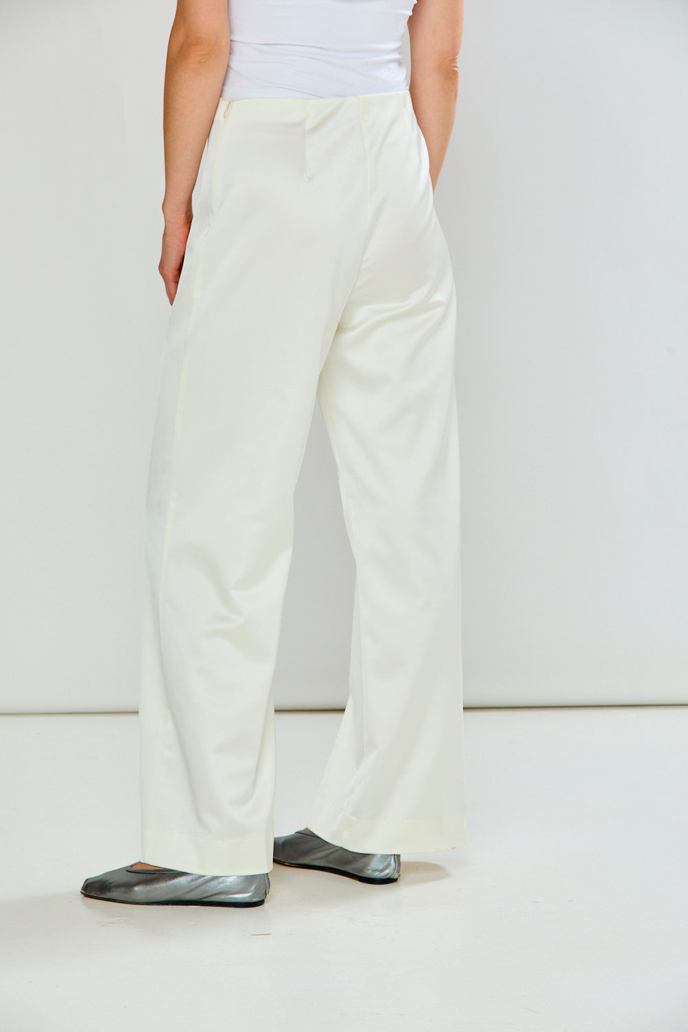 The Reyna Pant - Off White women's pants with a high waist and wide leg silhouette styled with a white top and silver flats.