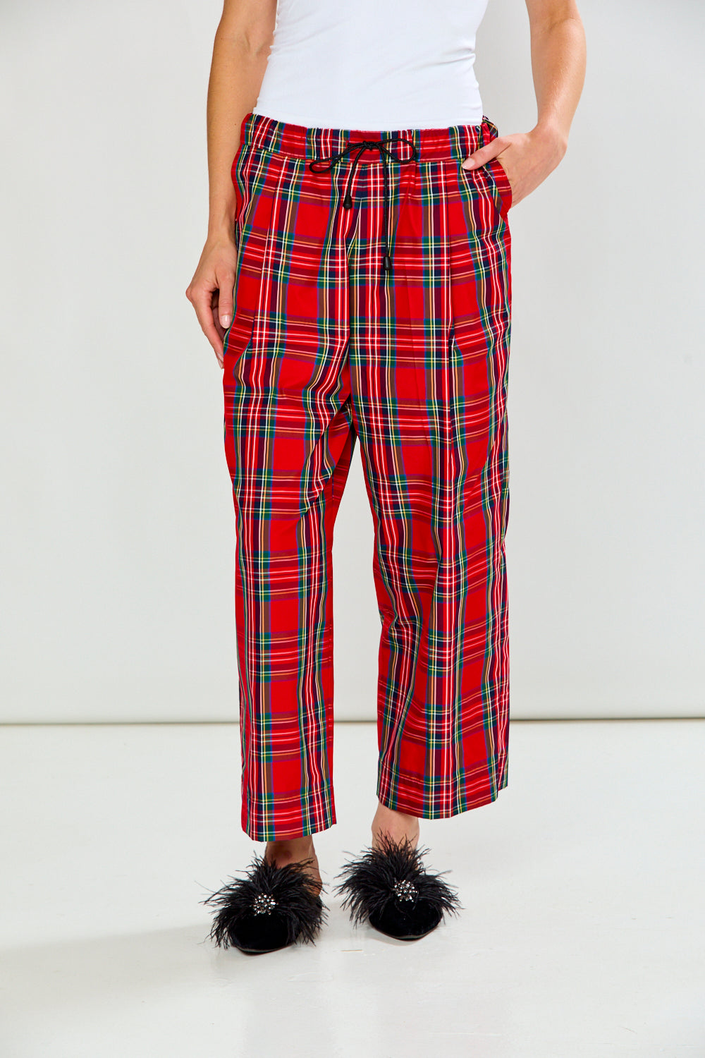 The Marcia Pant - Red Plaid shown on a model in cropped red plaid pants with a relaxed fit and side pockets styled with black feathered shoes