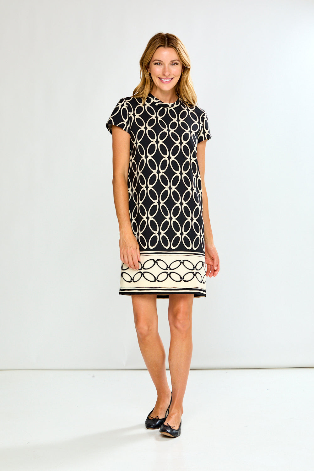 Woman wearing a black and white patterned dress on a white background