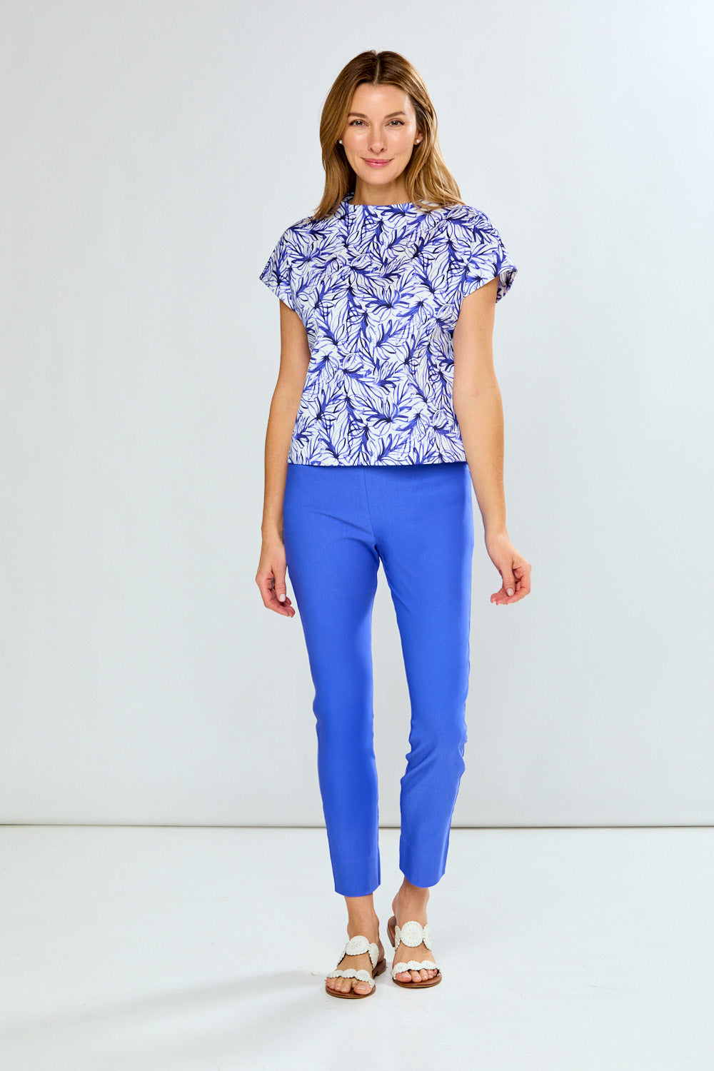 Woman wearing a blue and white patterned top with matching pants on a white background
