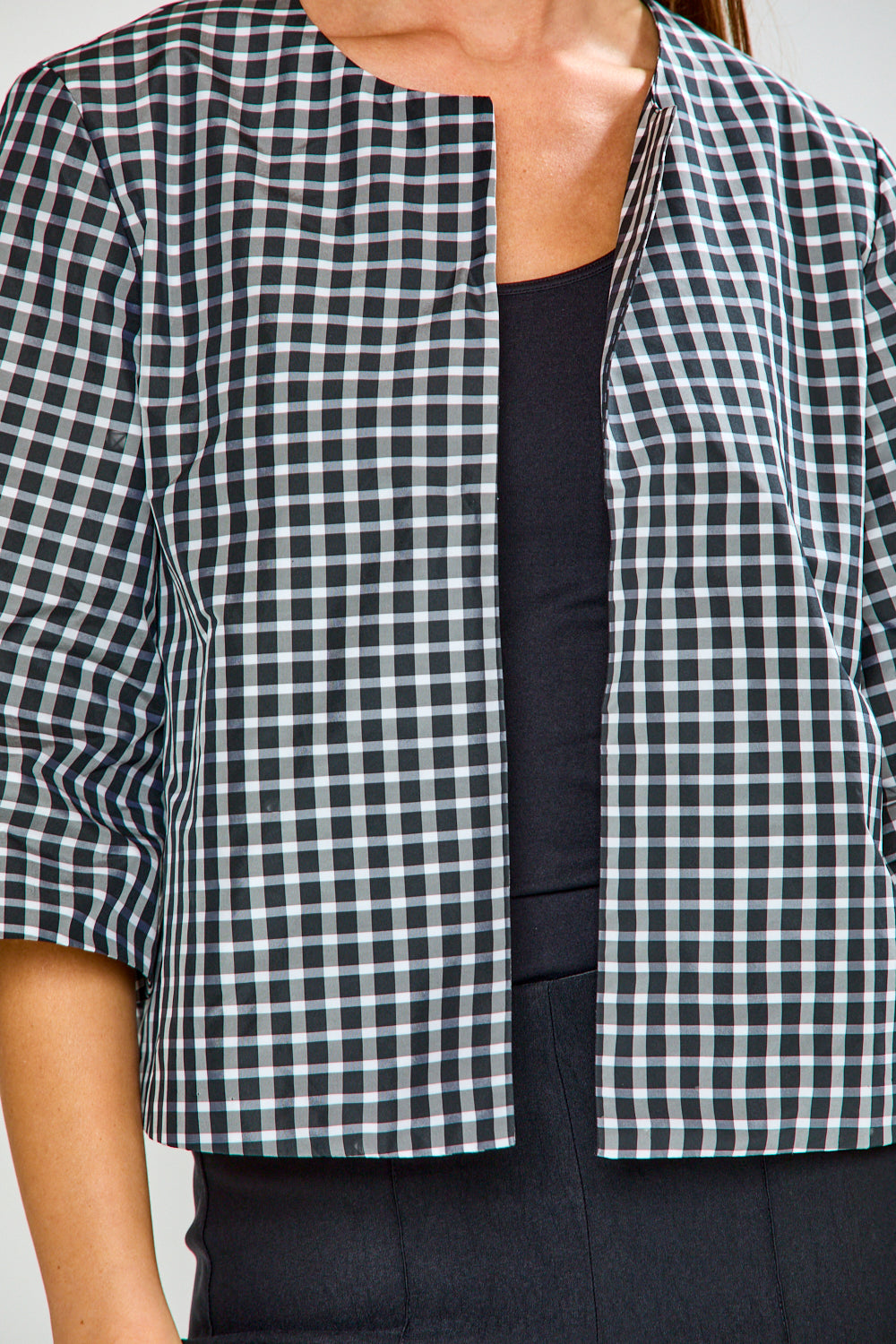 Black and white checkered shirt worn by a person, with a focus on the upper body.