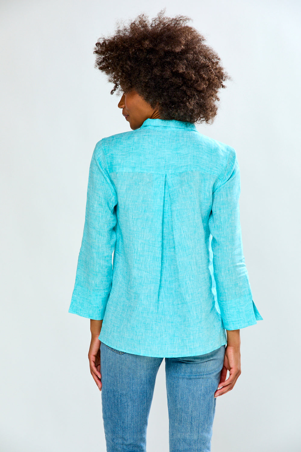 Person wearing a light blue blazer and jeans on a white background