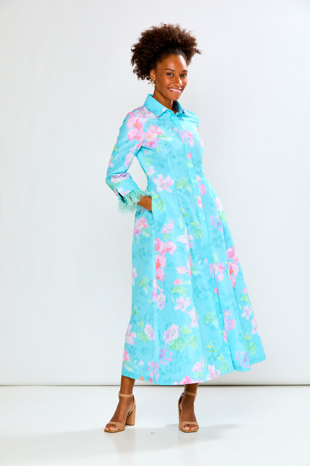 Woman wearing a light blue floral dress against a white background