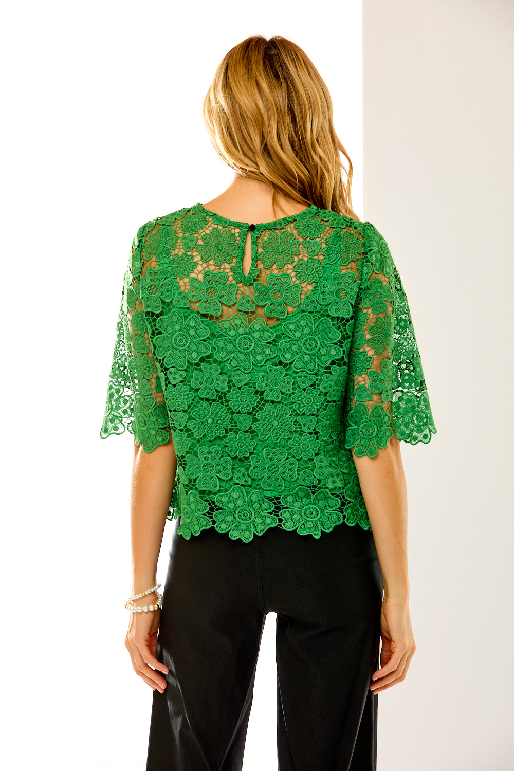 back of woman in green lace top 