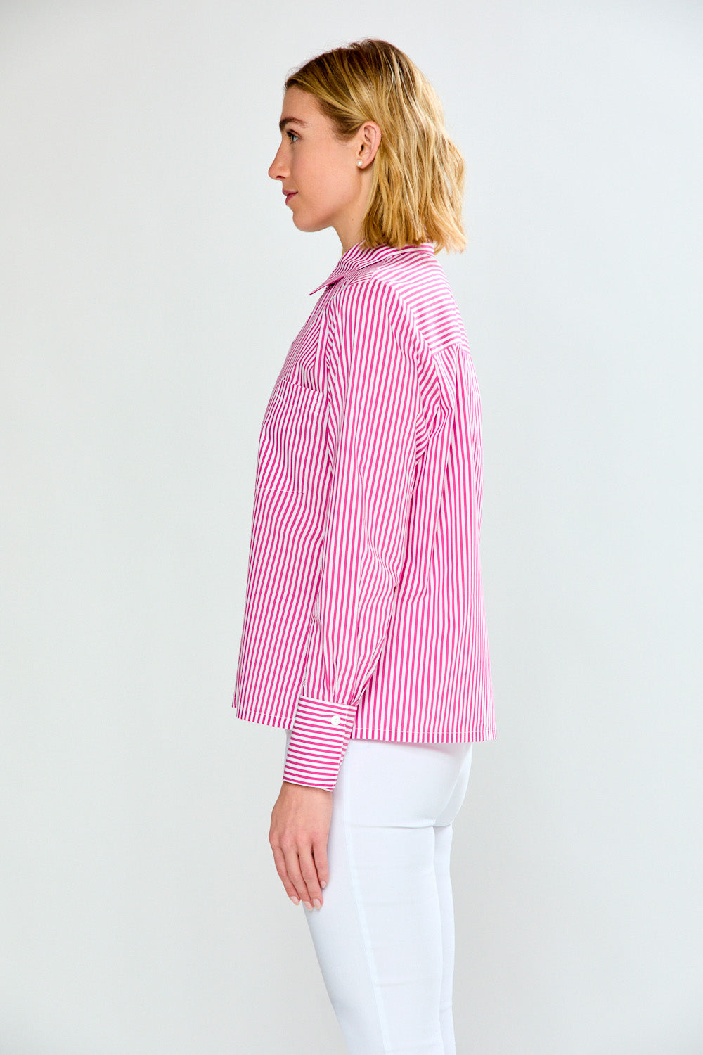 Woman wearing a pink and white striped shirt against a plain background