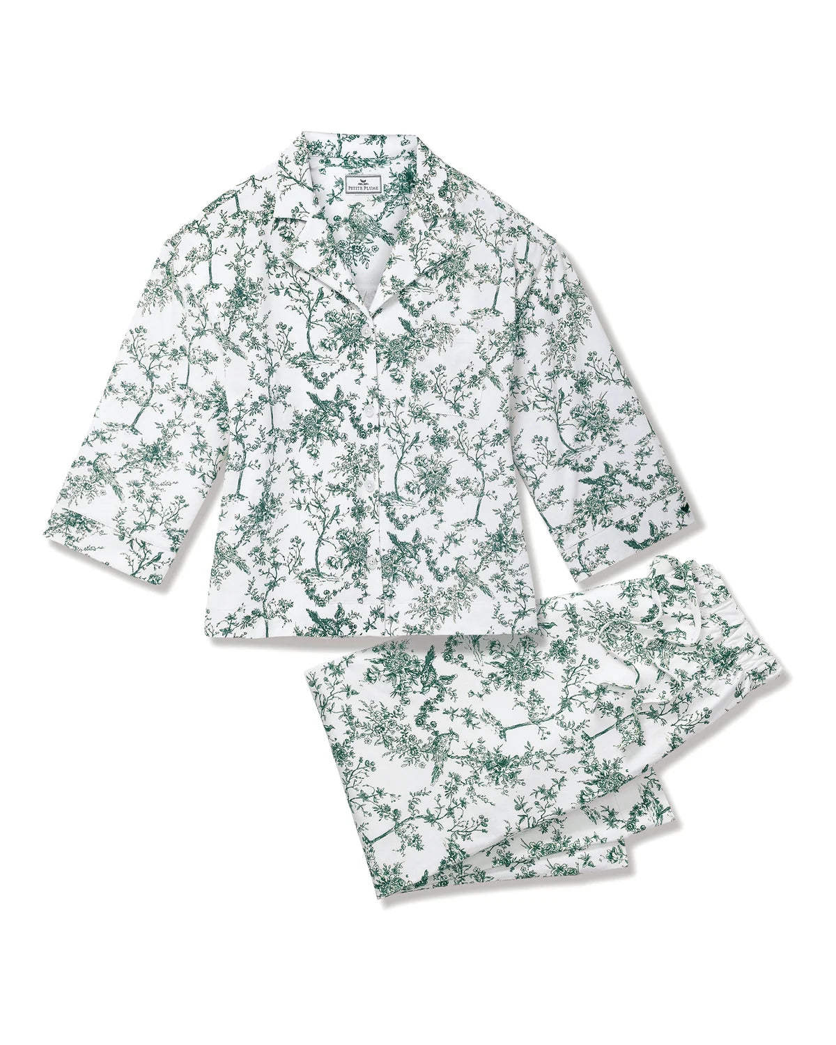A two-piece pajama set featuring a long-sleeve button-up shirt and matching shorts, both printed with a green botanical and bird pattern on a white background.