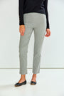 A person wearing light gray cropped trousers, a black long-sleeve top, and black flats, standing against a plain white studio background.