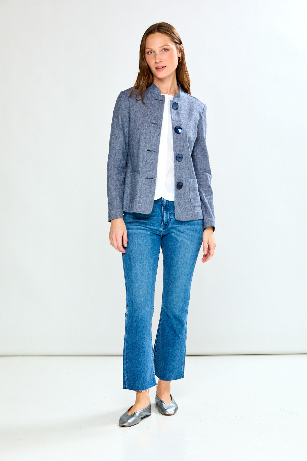 Woman wearing a blue blazer and jeans on a white background