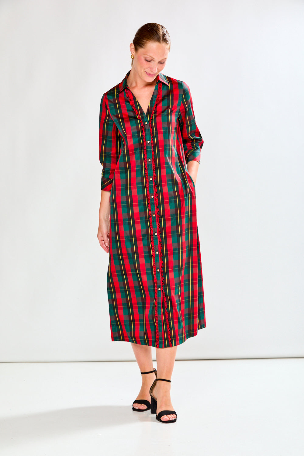 Woman wearing a red and green plaid dress on a white background