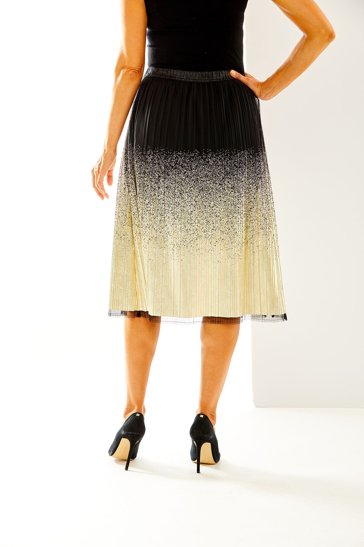 Woman in black and gold midi skirt