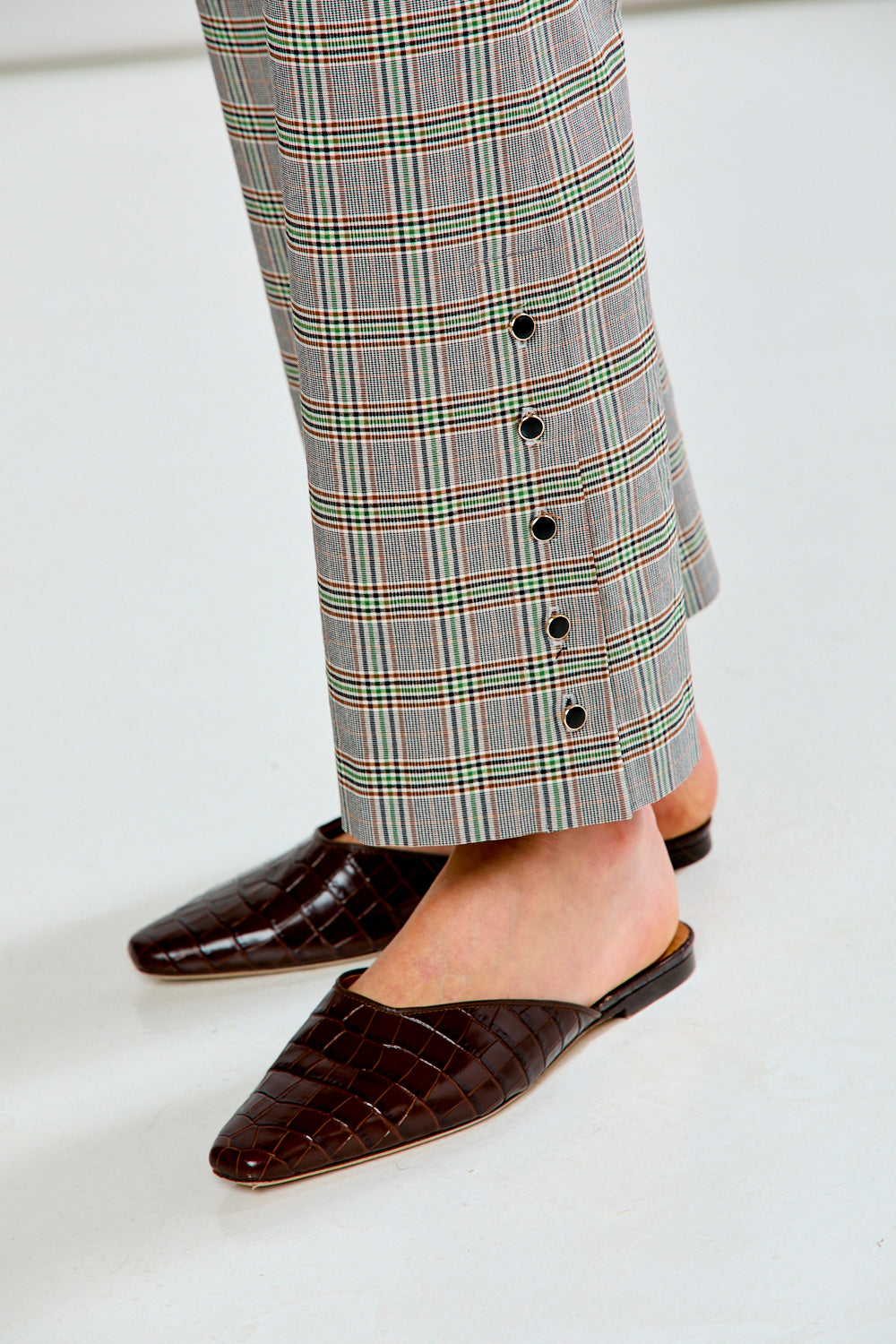 Person wearing plaid pants on a white background