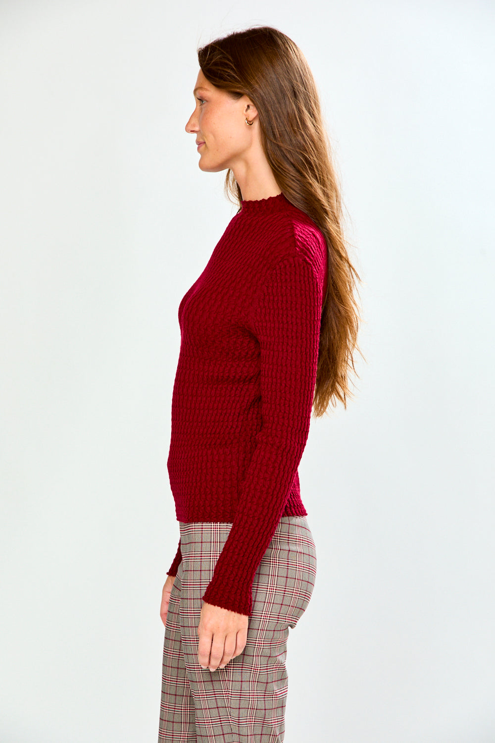 The Texture Long Sleeve in Aubergine shown on a model as a textured womens sweater styled with plaid pants