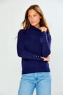 The Turtleneck With Button Cuffs - Navy worn by a woman with light blue jeans in a chic classic outfit