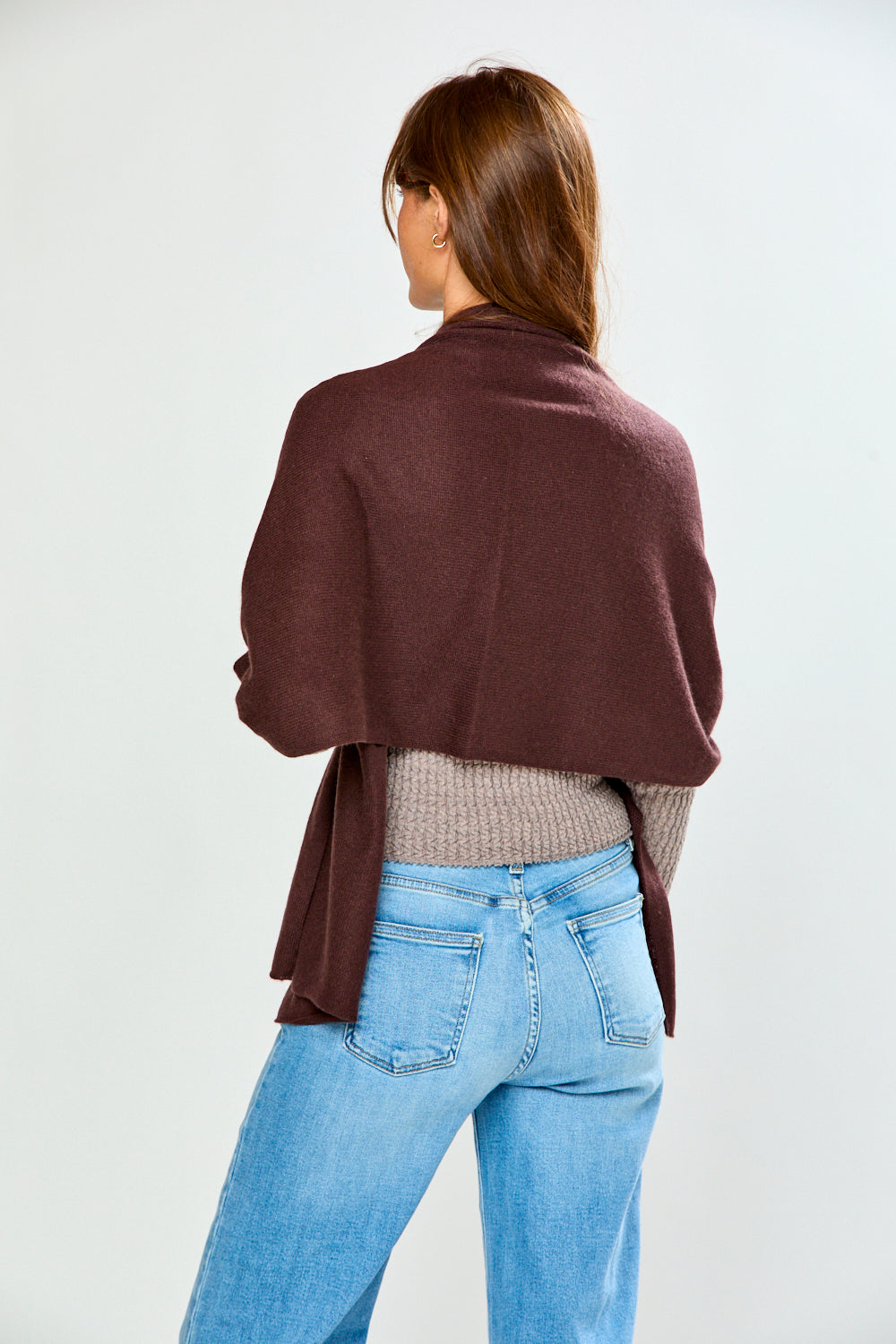 The Classic Cashmere Scarf in rich brown cashmere draped over a model for a sophisticated timeless fashion accessory look