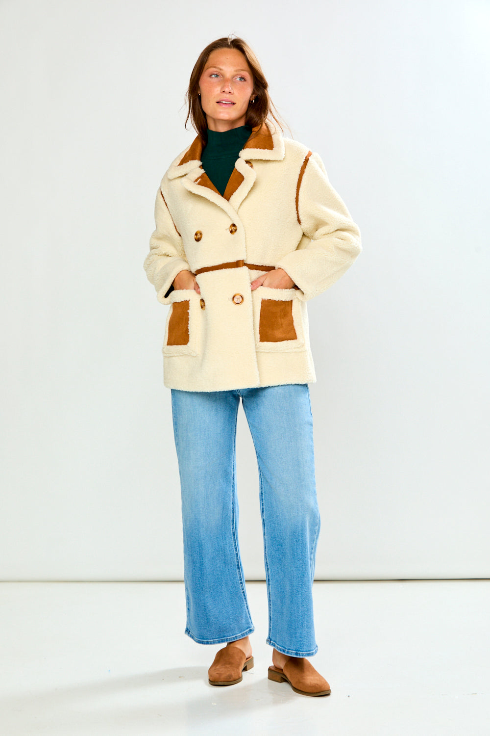 Woman wearing The Phoenix Coat - Tan with light blue jeans and brown shoes in a chic timeless outfit