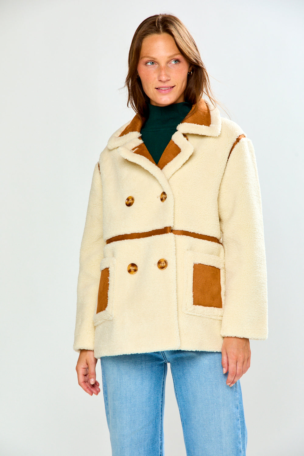 The Phoenix Coat - Tan in soft shearling with brown trim and patch pockets styled with jeans for a chic classic look