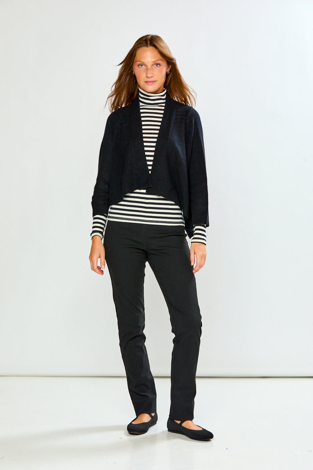 The Shrug with Kimono Sleeves in Black styled with a striped turtleneck and black pants for a chic sophisticated women's sweater look