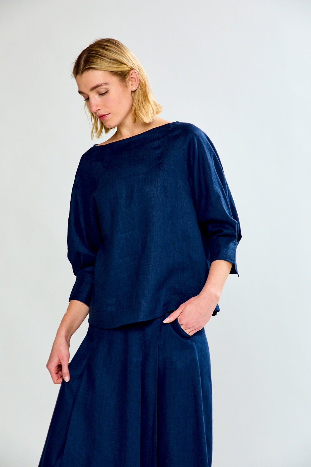 Woman wearing a navy blue outfit against a plain background