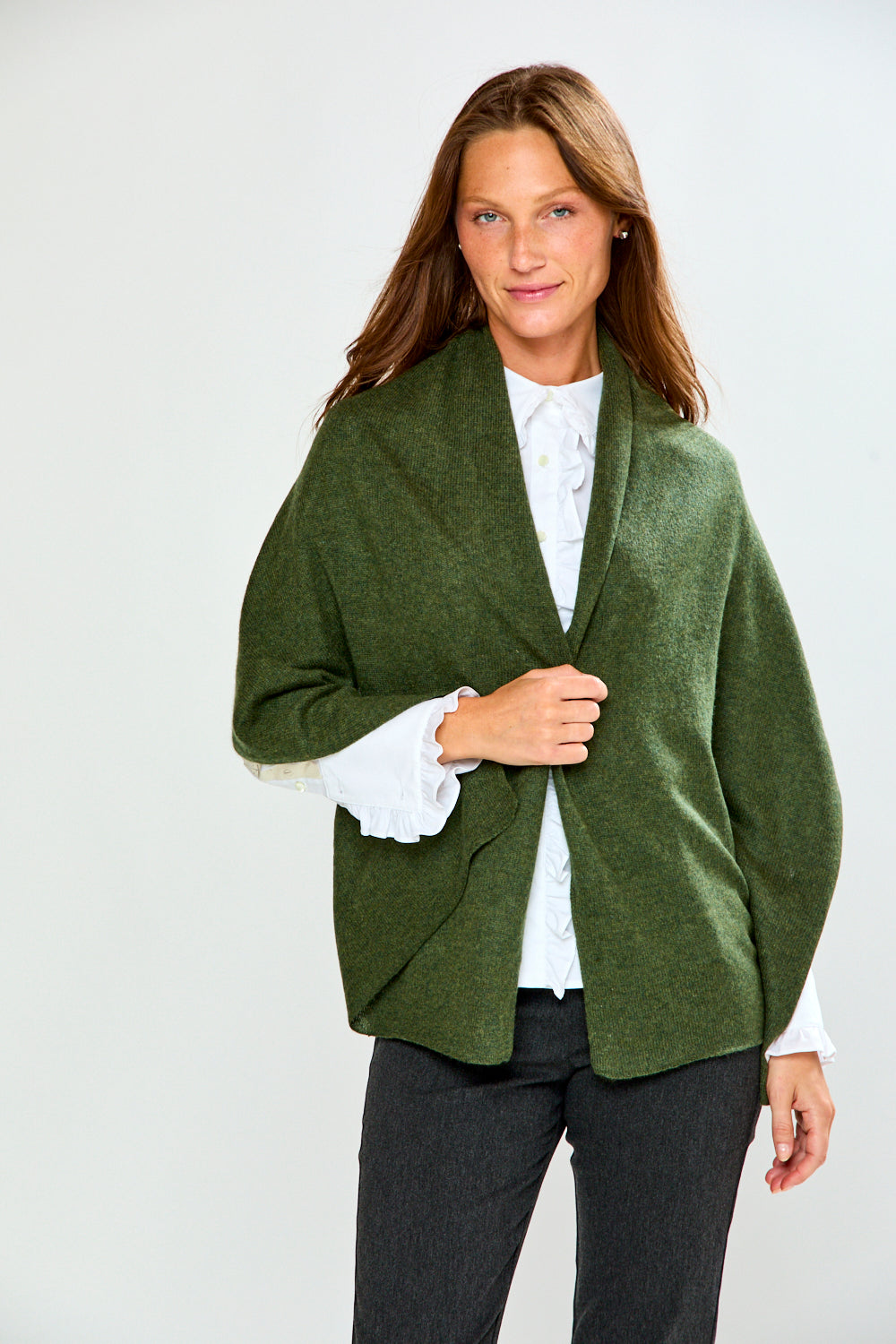 The Classic Cashmere Scarf styled as a green wrap over a white blouse and dark pants on a woman in a studio setting