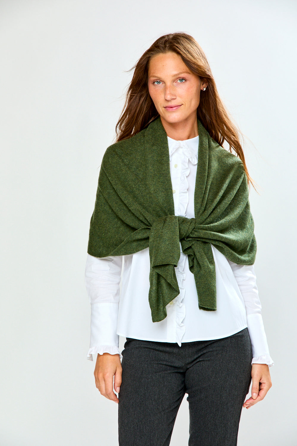 The Classic Cashmere Scarf in green cashmere draped as a wrap over a white blouse for a chic timeless accessory look